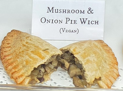 A delicious Pie Wich hand pie opened to show the ingredients, along with a card indicating the flavor.