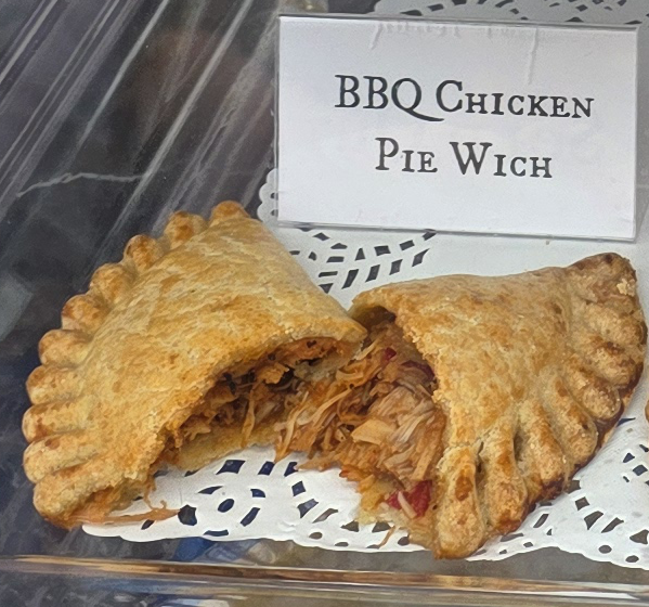 A delicious Pie Wich hand pie opened to show the ingredients, along with a card indicating the flavor.