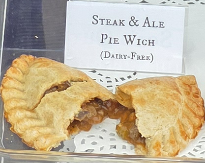 A delicious Pie Wich hand pie opened to show the ingredients, along with a card indicating the flavor.