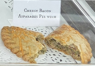 A delicious Pie Wich hand pie opened to show the ingredients, along with a card indicating the flavor.
