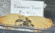 A delicious Pie Wich hand pie opened to show the ingredients, along with a card indicating the flavor.