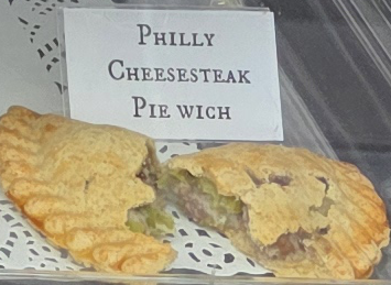 A delicious Pie Wich hand pie opened to show the ingredients, along with a card indicating the flavor.