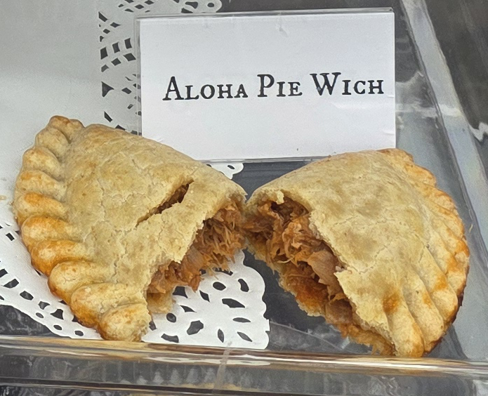 A delicious Pie Wich hand pie opened to show the ingredients, along with a card indicating the flavor.