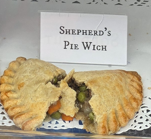 A delicious Pie Wich hand pie opened to show the ingredients, along with a card indicating the flavor.