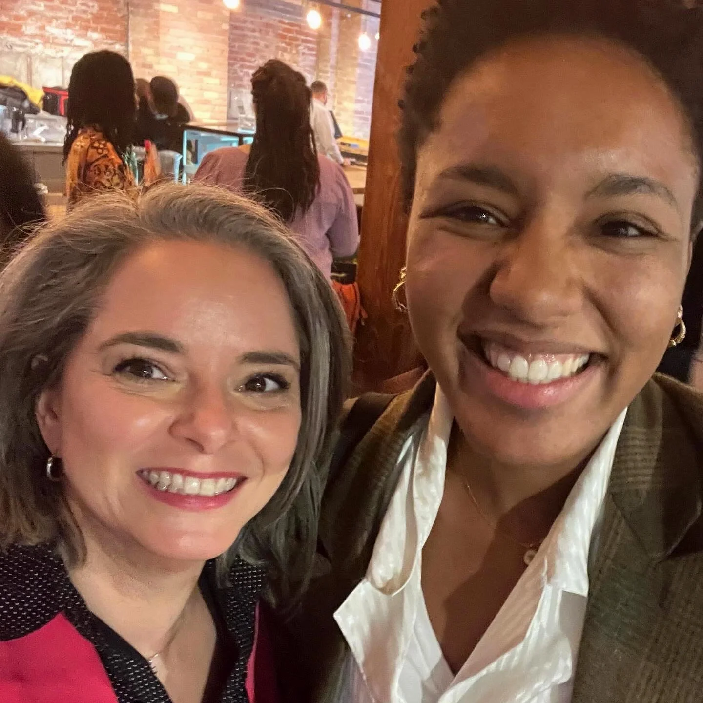 Heather Kelly and N'deye-Arame Kebe smile standing together at a gala event