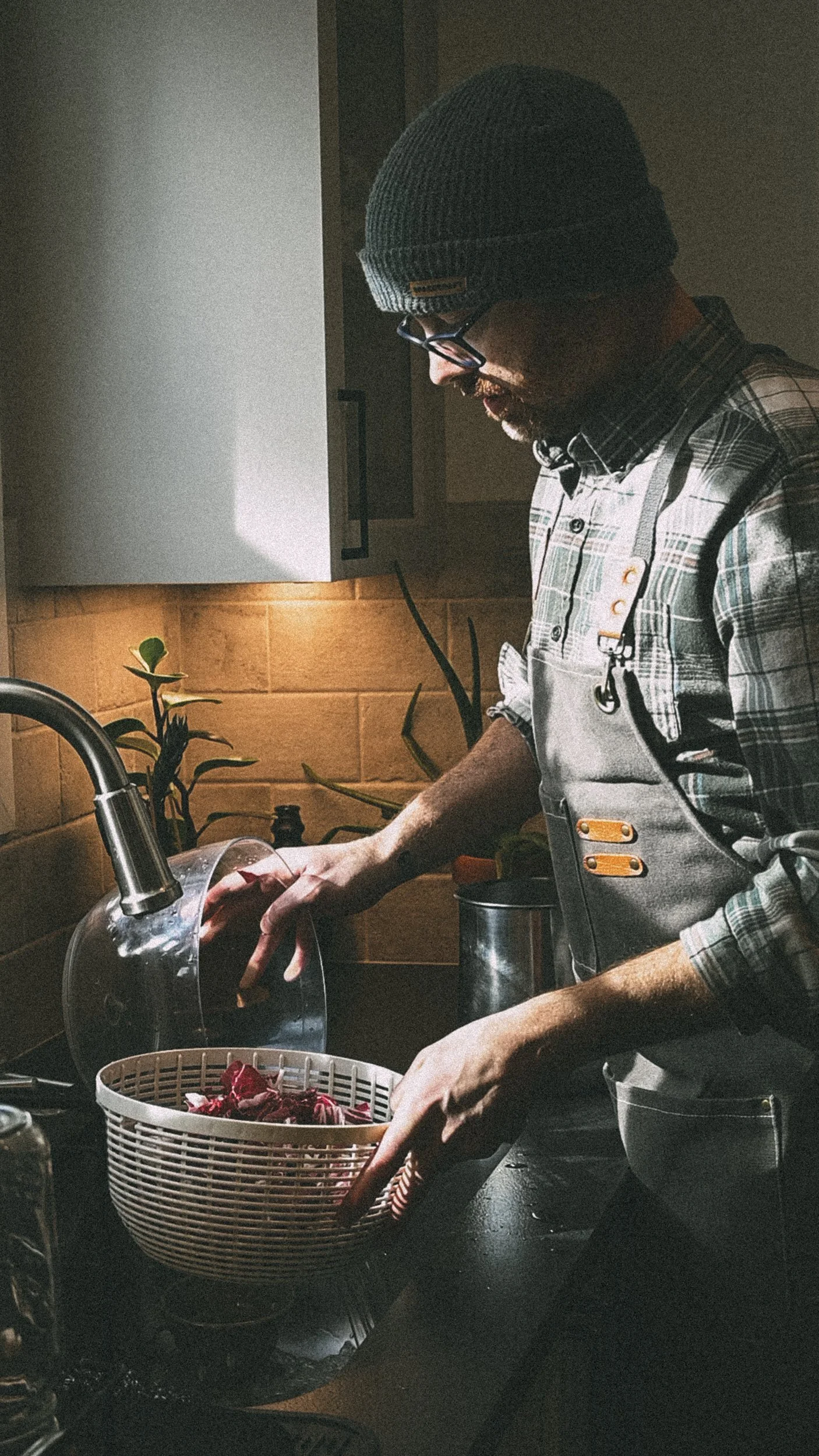 cody chef washing fresh produce in a sink