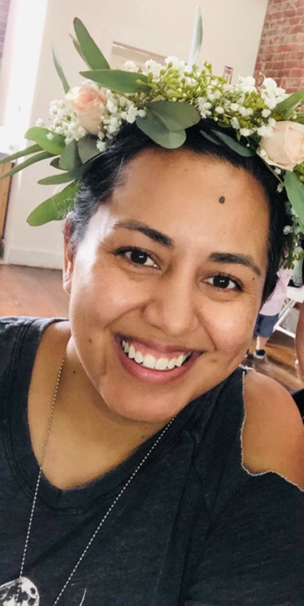 young woman with black hair wearing flowers on her head