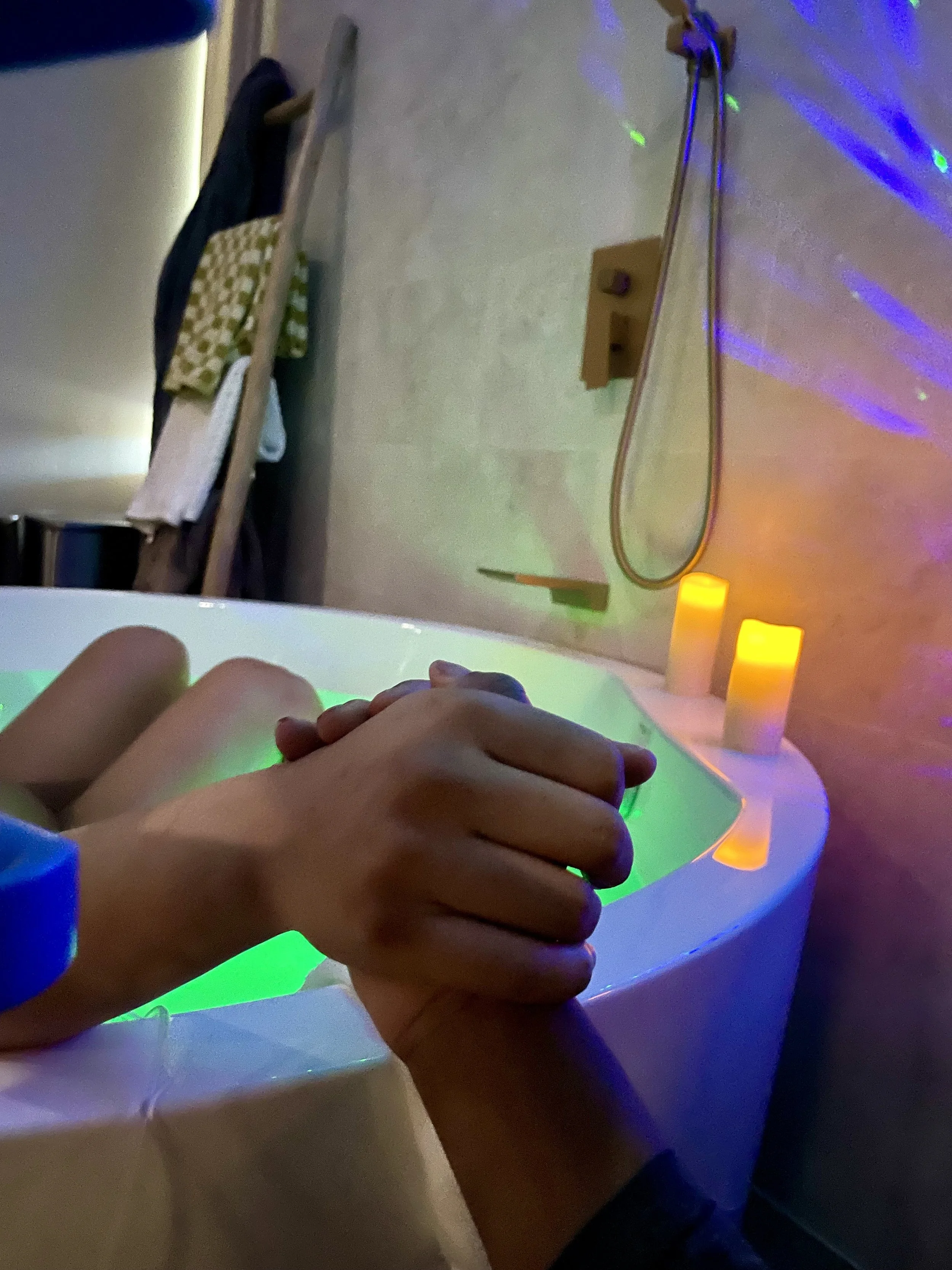 Person signing a document at a desk with a pen, surrounded by papers, a smartphone, and a laptop.