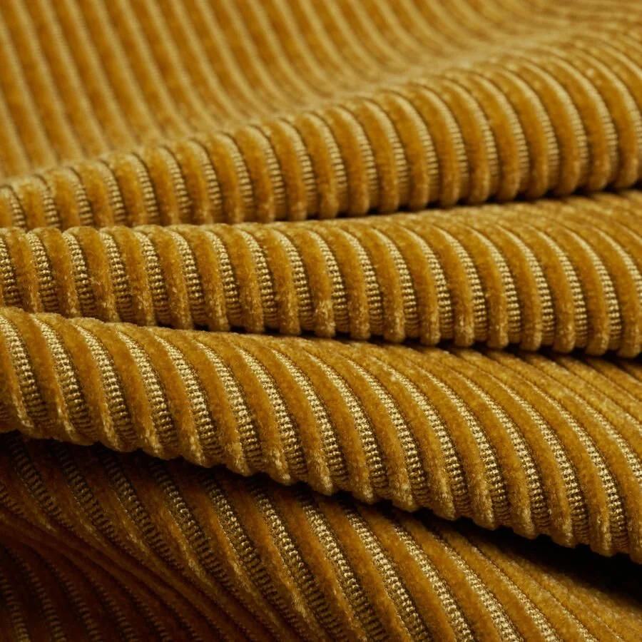 Close-up of mustard yellow corduroy fabric with vertical ridges.
