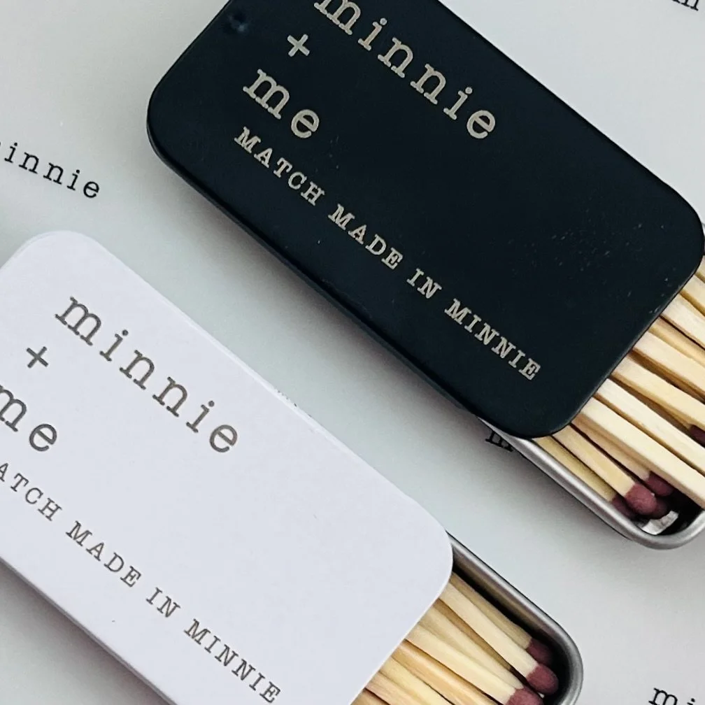 Two tins of matches labeled 'minnie + me' and 'minnie', with wooden matchsticks inside.