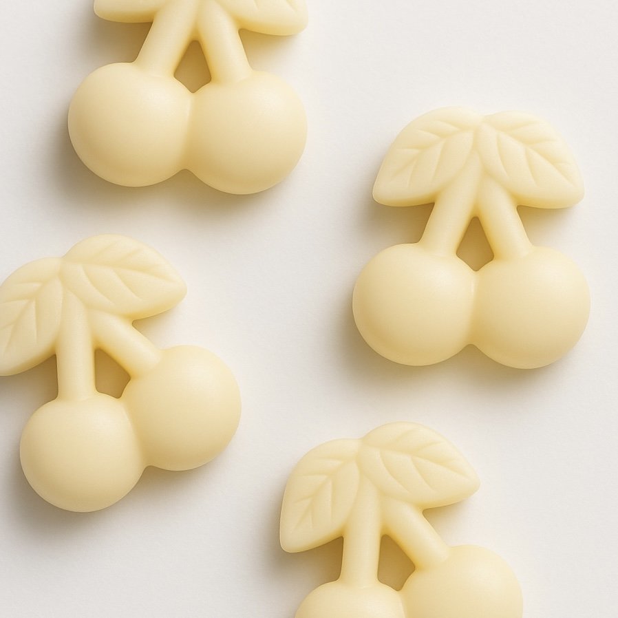 Creamy white cherry-shaped soy wax melts with leaf details, styled on a light background.
