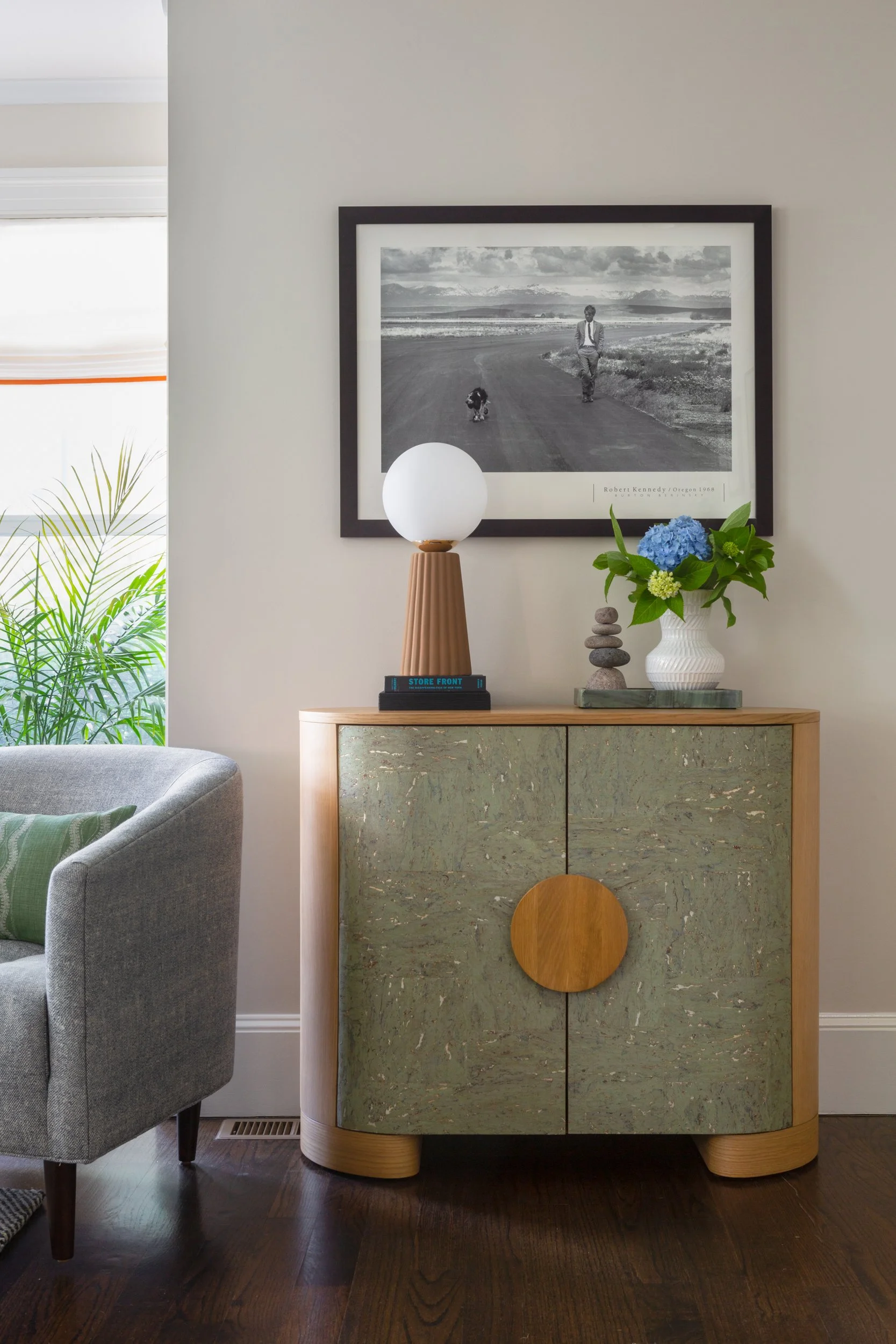An entryway with a contemporary console, table lamp, and a large black and white photograph on the wall.