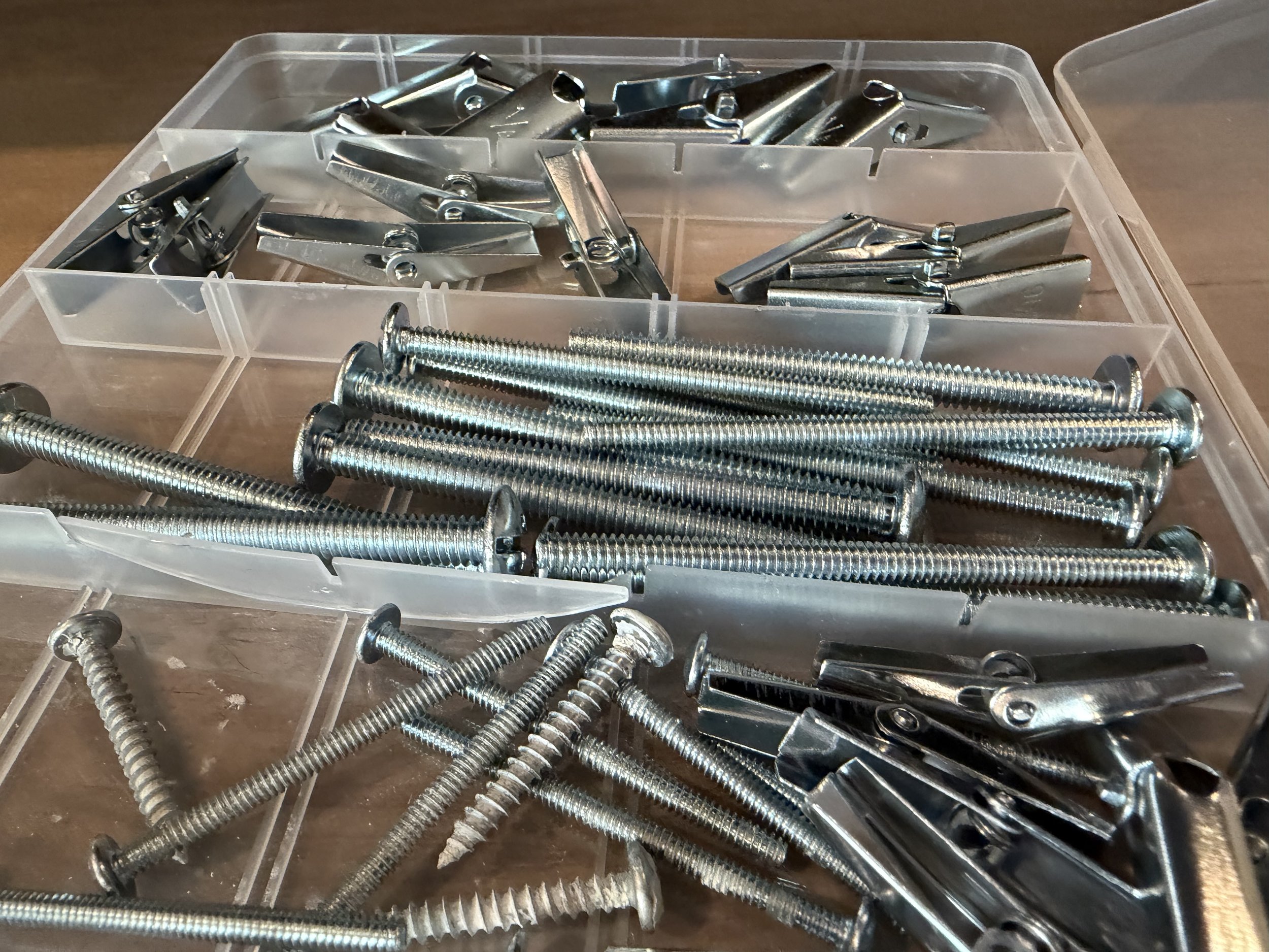 A technical display of modular office furniture hardware, including steel mounting brackets and industrial fasteners used by SLLET Solutions for commercial workspace transitions.