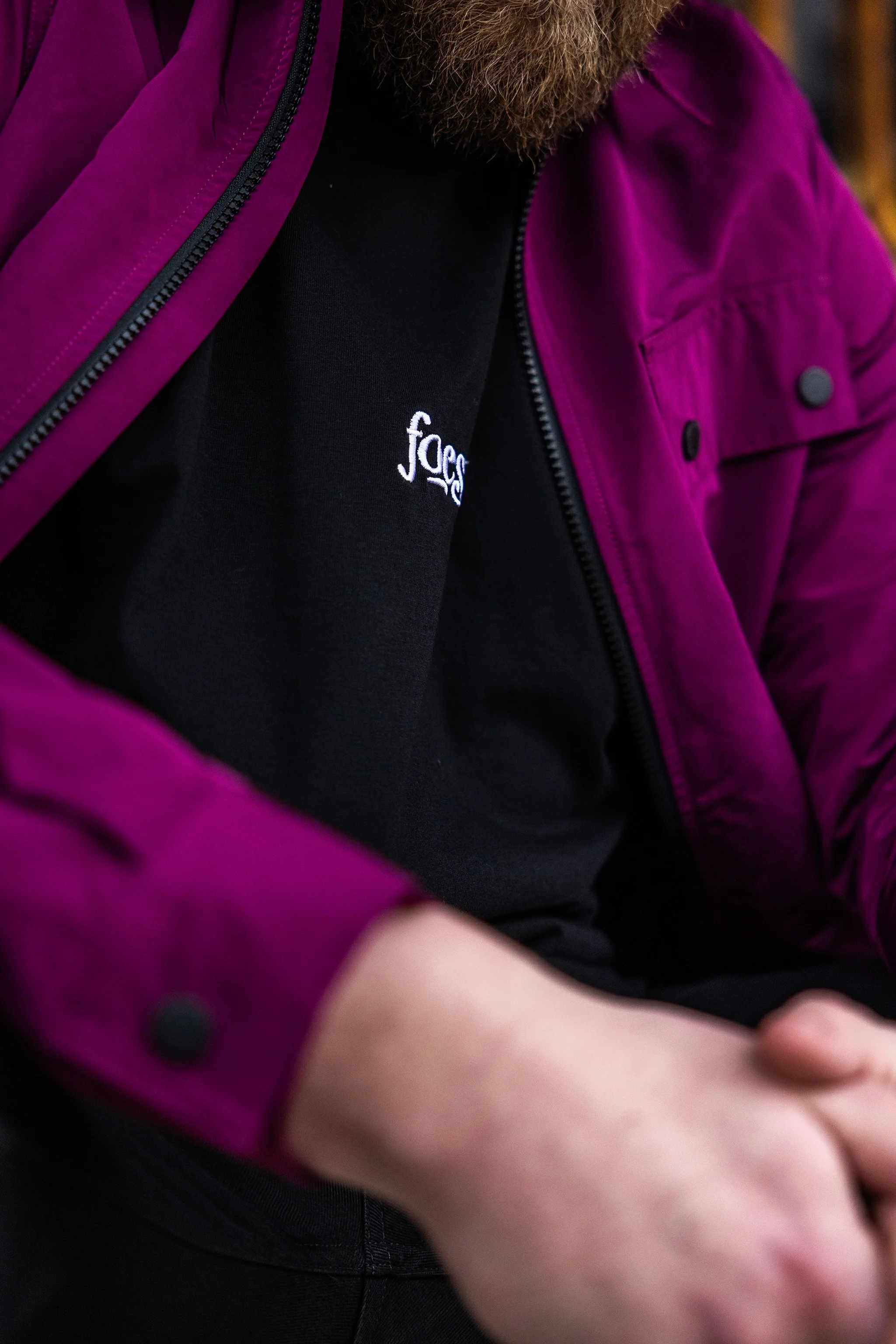 A person wearing black oversized t-shirt with embroidered logo