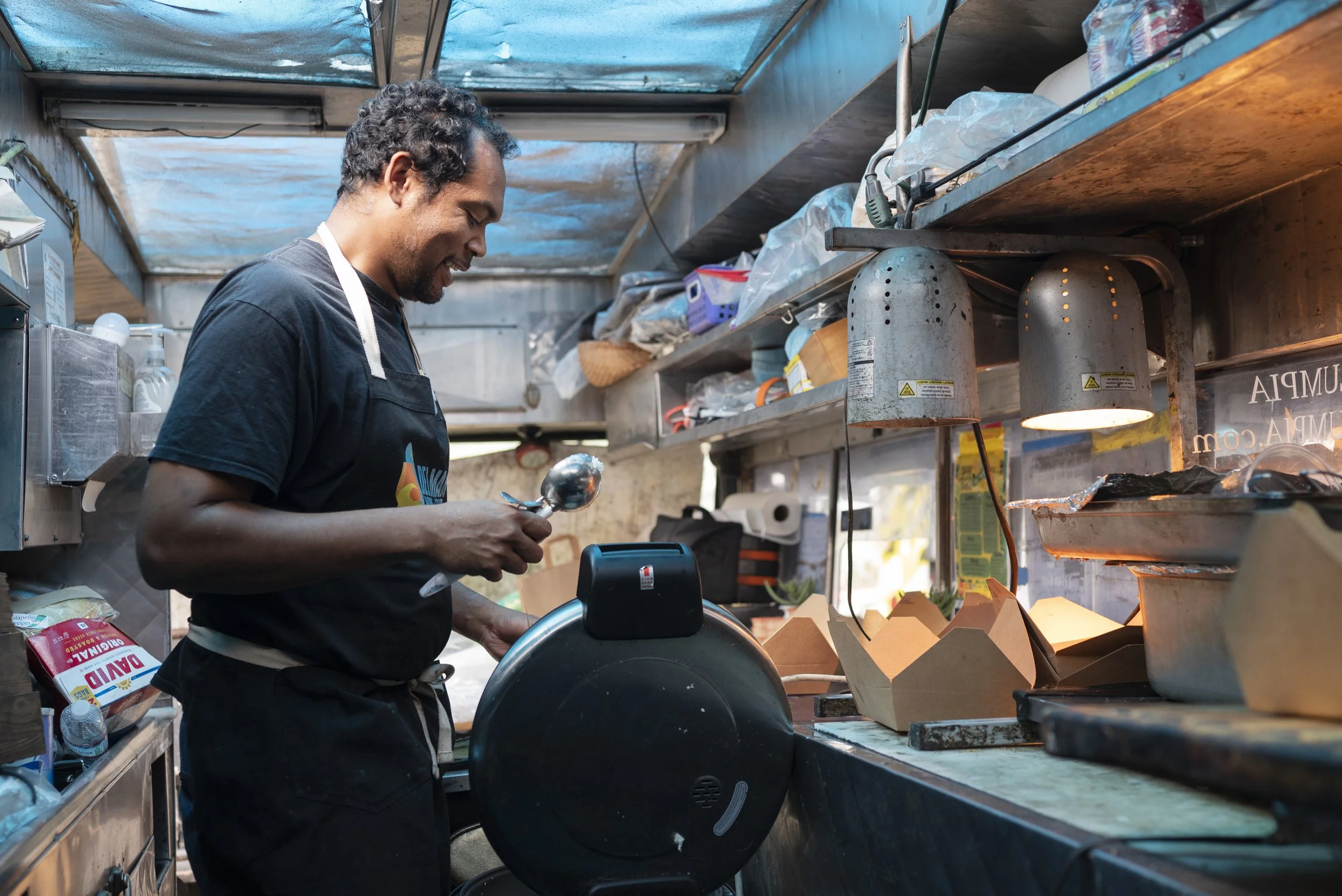 Spencer Hunter, chef and owner of Lia’s Lumpia, prepares lunch inside his food truck during a catered lunch at Google’s San Diego office on Feb. 19, 2026. (McKenzie Patterson / For The San Diego Union-Tribune)