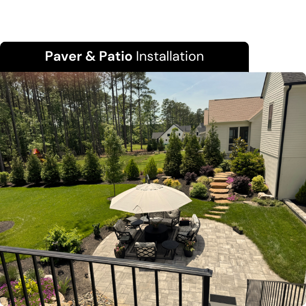 Backyard with paver patio, outdoor furniture, umbrella, and landscaped garden with trees and shrubs. Installed by B & C Designs in the Triangle, North Carolina.