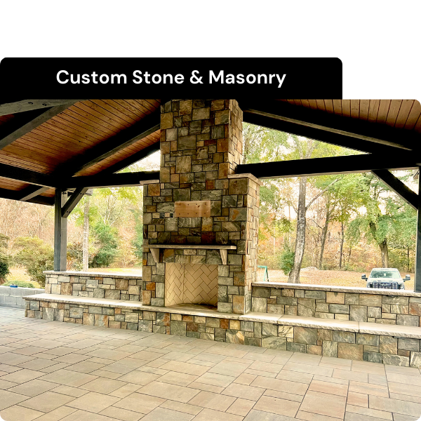 Outdoor pavilion with stone fireplace and seating area, advertising custom stone and masonry services. Installed by B & C Designs in the Triangle, North Carolina.