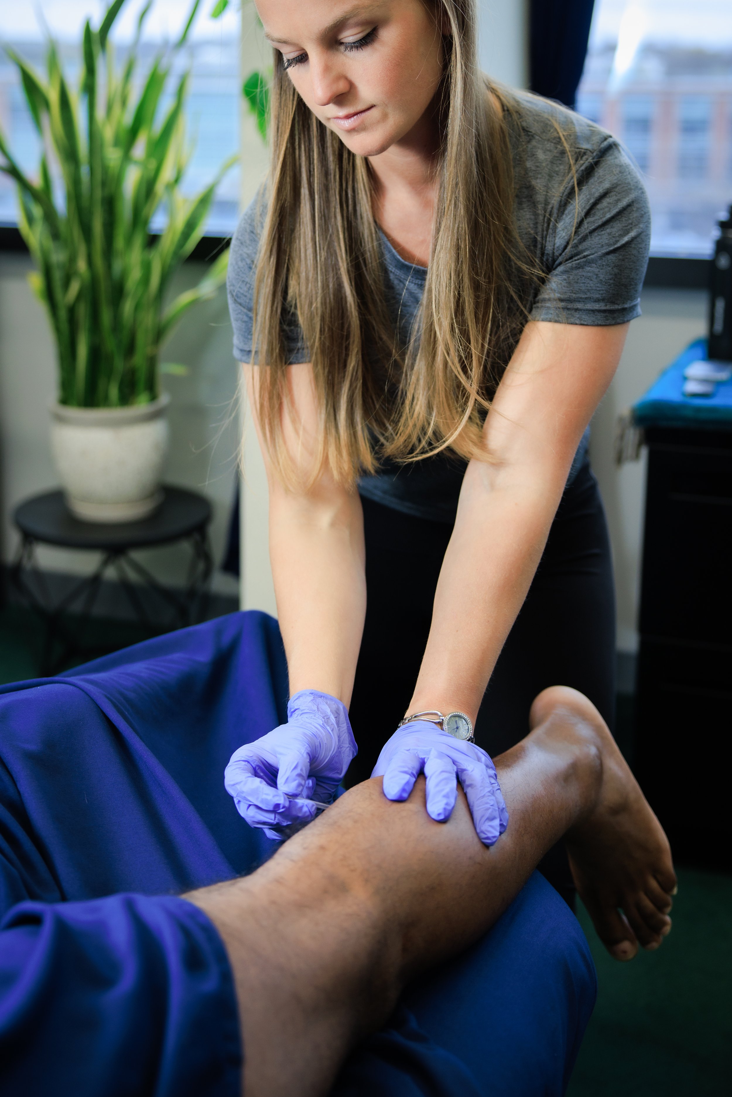 Physical therapist performing dry needling on a man's calf