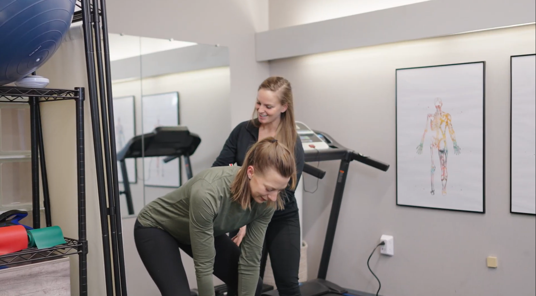 physical thearpist critiquing form of a women picking up weight from the floor