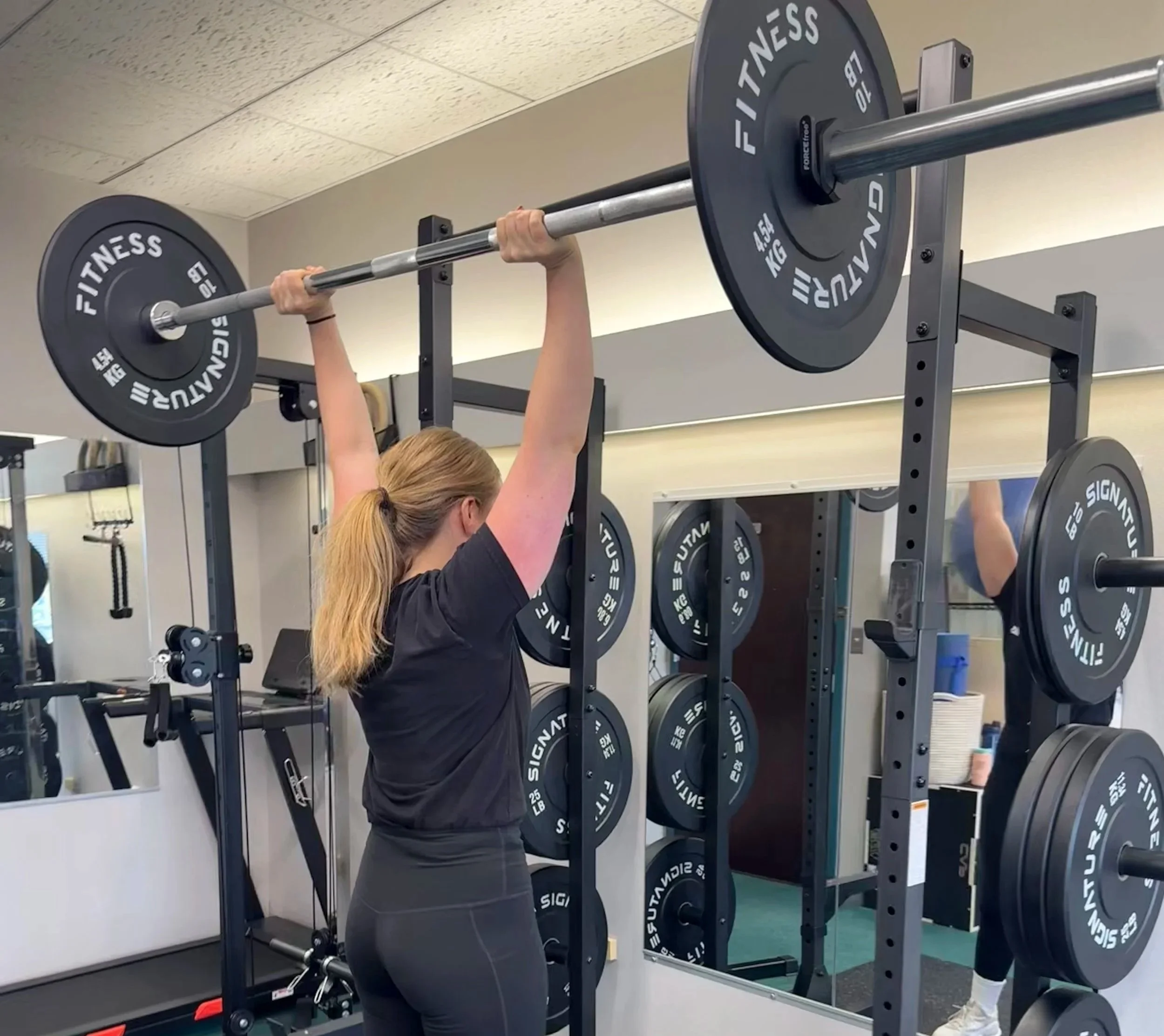 Strong woman lifting weight overhead