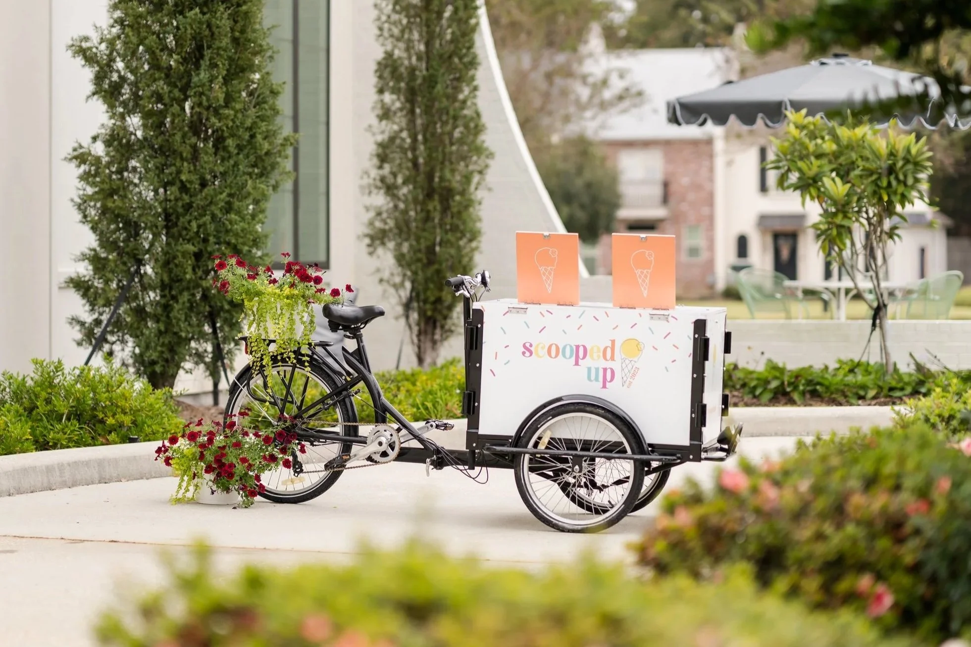An white ice cream tricycle cart set for an event.