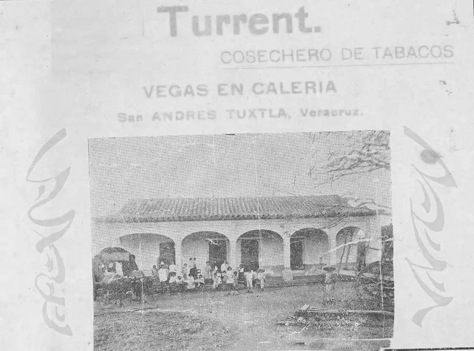 A Historic photograph of the Turrent family's tobacco hacienda in San Andrés Tuxtla, Veracruz, with arched porticos and workers gathered outside — labeled "Turrent, Cosechero de Tabacos.