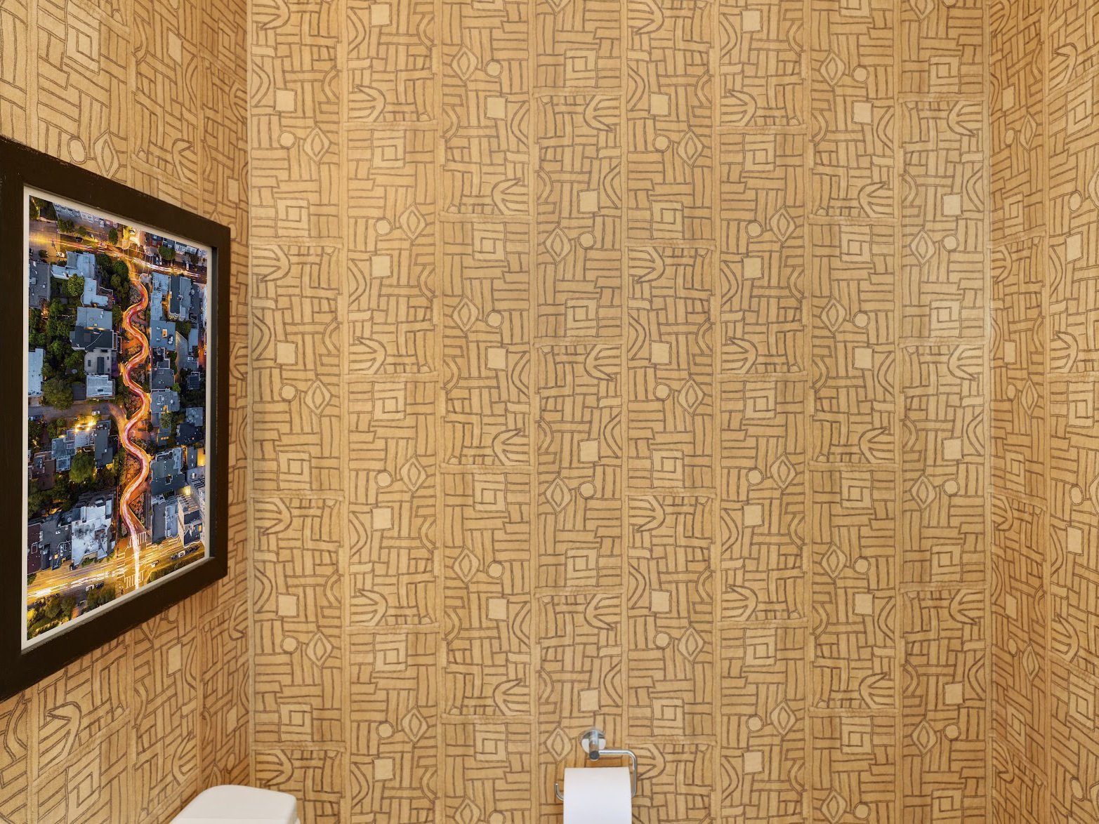 A bold and visually striking powder room featuring intricate geometric-patterned wallpaper in warm tan and beige tones, creating a dynamic and textured backdrop. On the left wall, a framed aerial photograph of San Francisco’s winding Lombard Street a