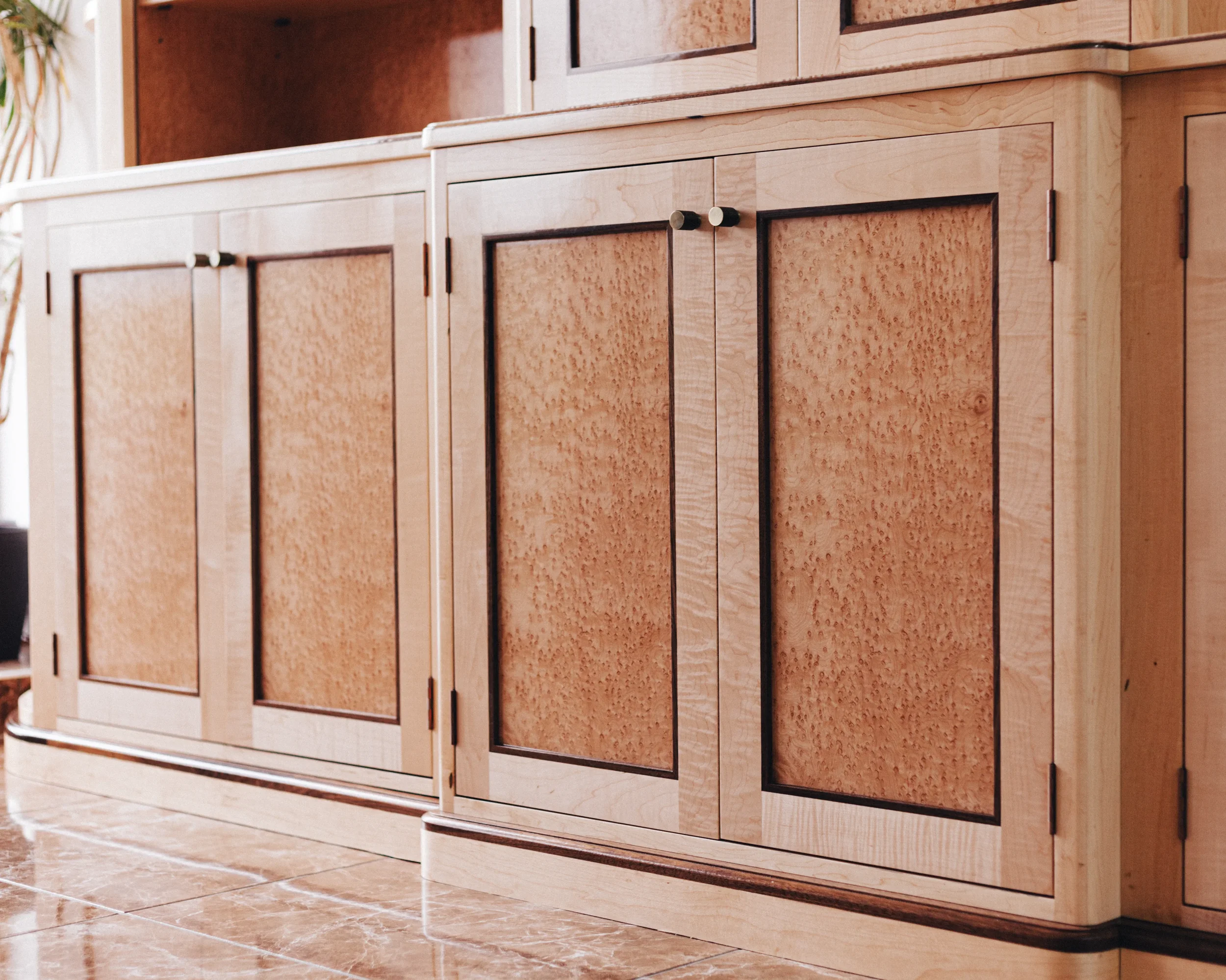 A prepared veneer Birdseye Maple and American Black Walnut shaker doors with contemporary knobs