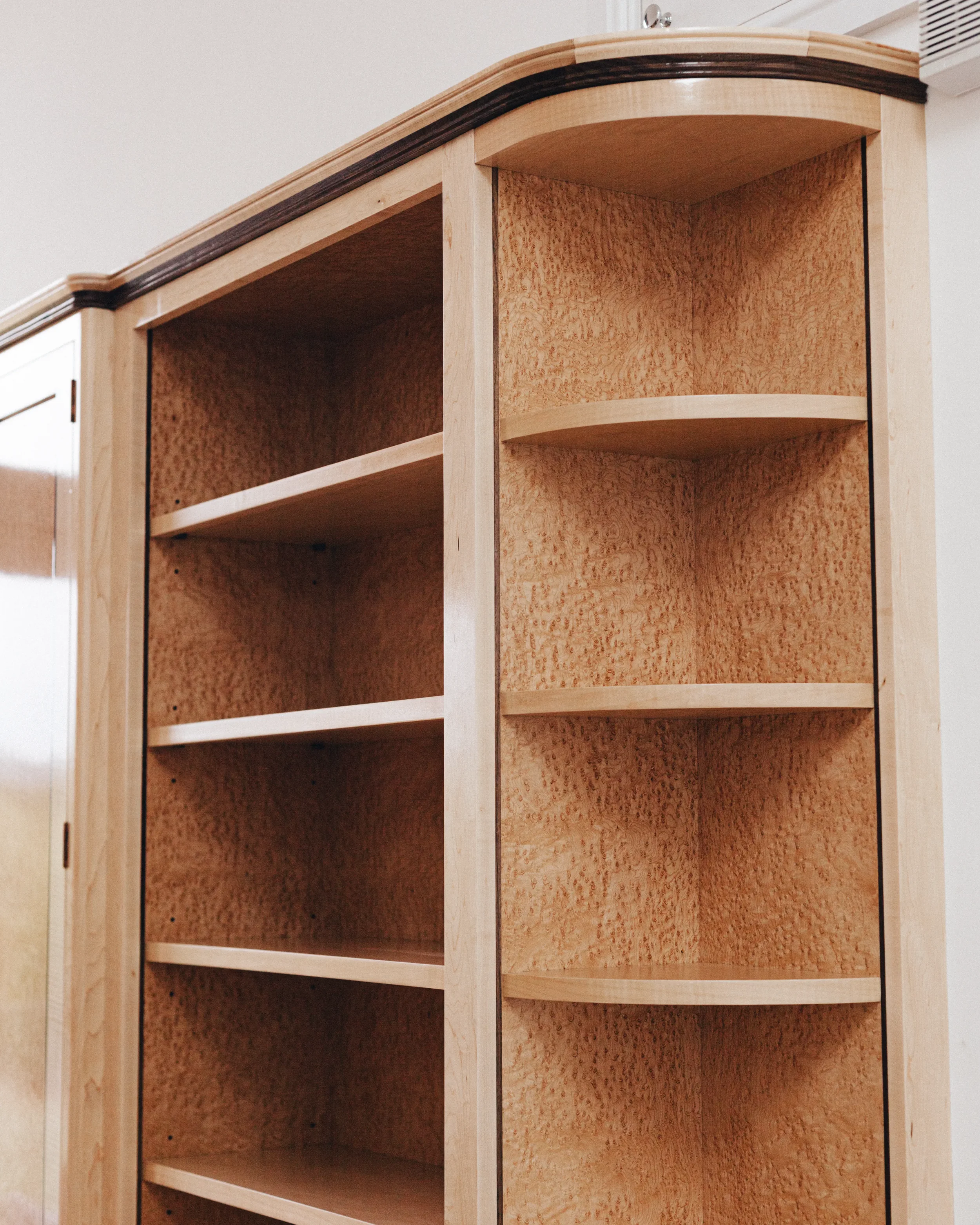 A prepared veneer Birdseye Maple and American Black Walnut shelving unit in a high gloss finish with dramatic figuring and curved shelving