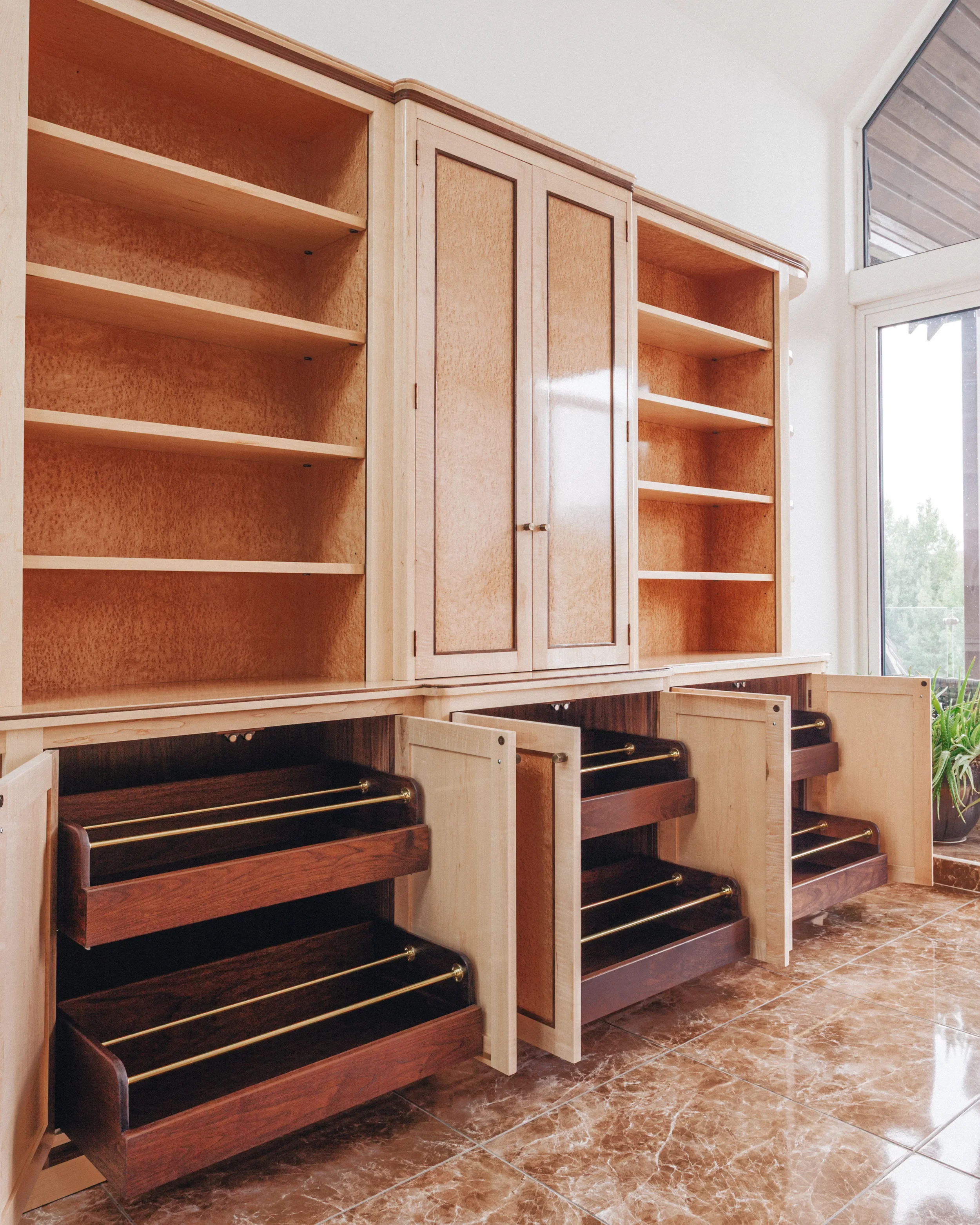 A prepared veneer Birdseye Maple and American Black Walnut shelving unit in a high gloss finish with dramatic figuring and curved shelving featuring solid Walnut shoe storage drawers with brass support rods