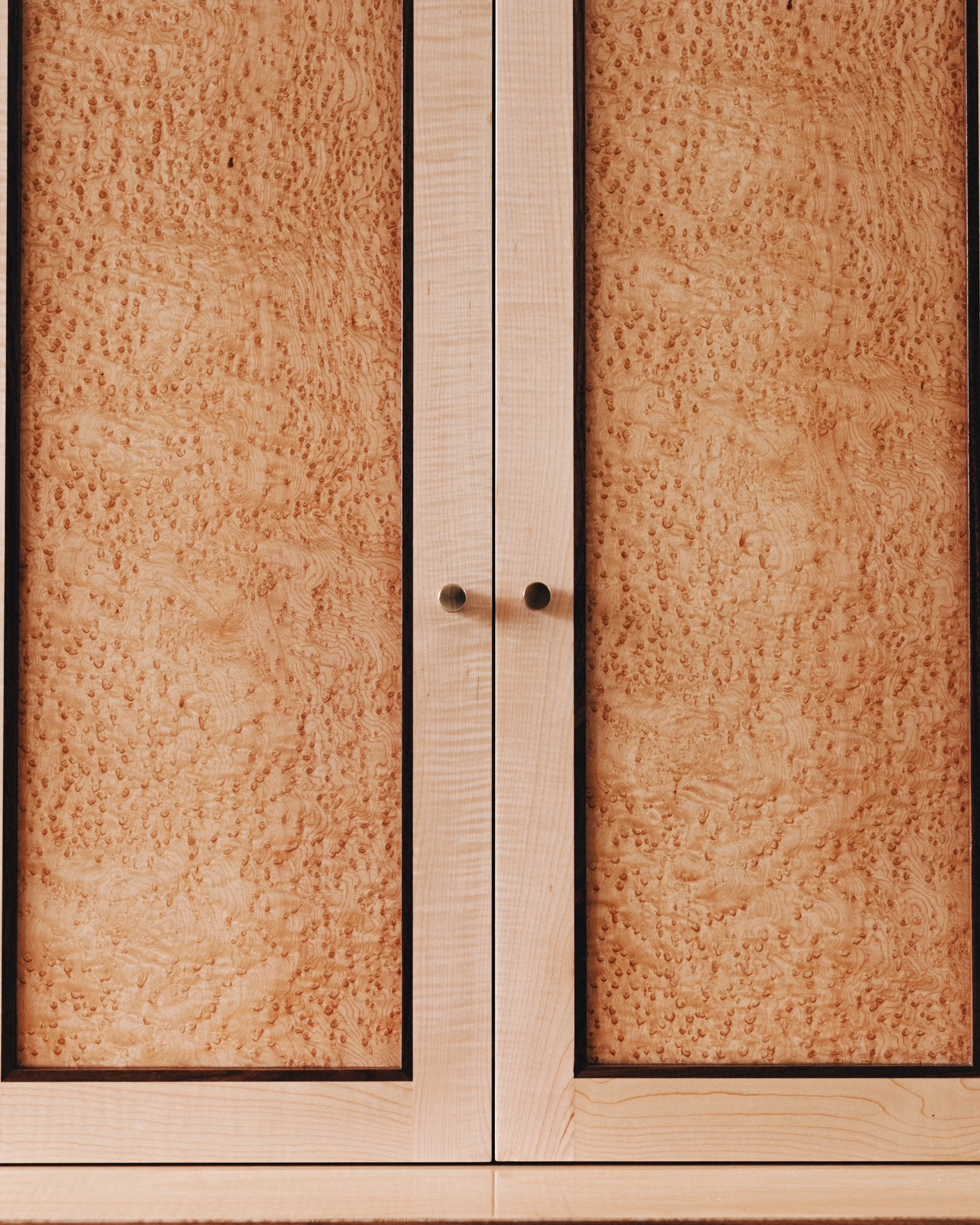 A prepared veneer Birdseye Maple and American Black Walnut shaker doors with contemporary knobs