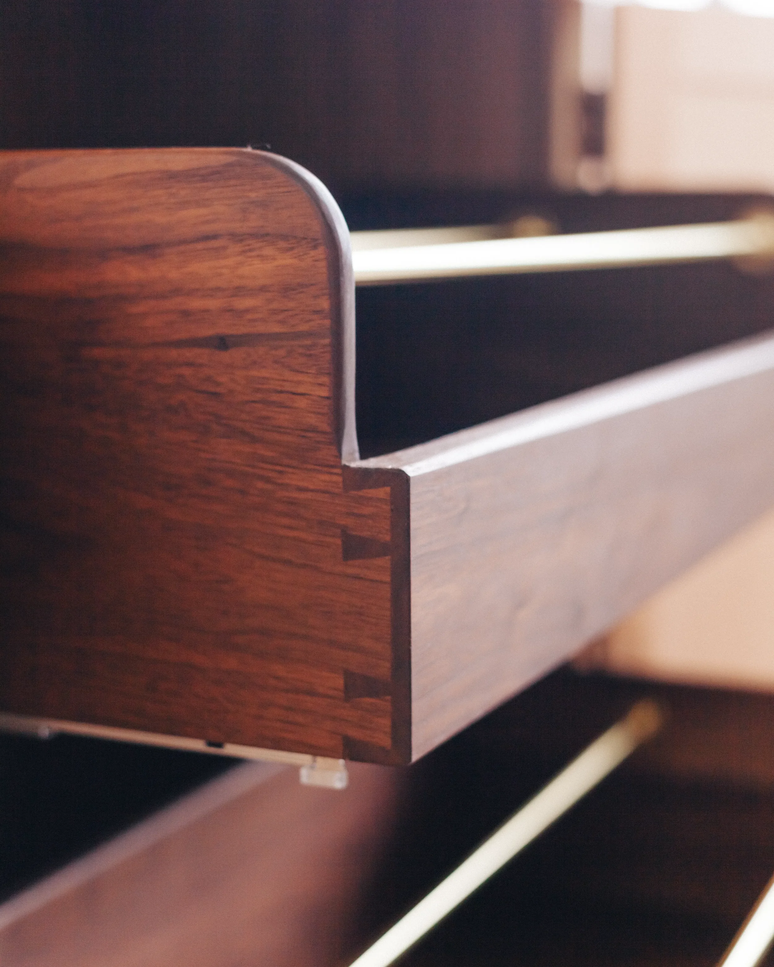 A prepared veneer Birdseye Maple and American Black Walnut shelving unit in a high gloss finish with dramatic figuring and curved shelving featuring solid Walnut shoe storage drawers with brass support rods