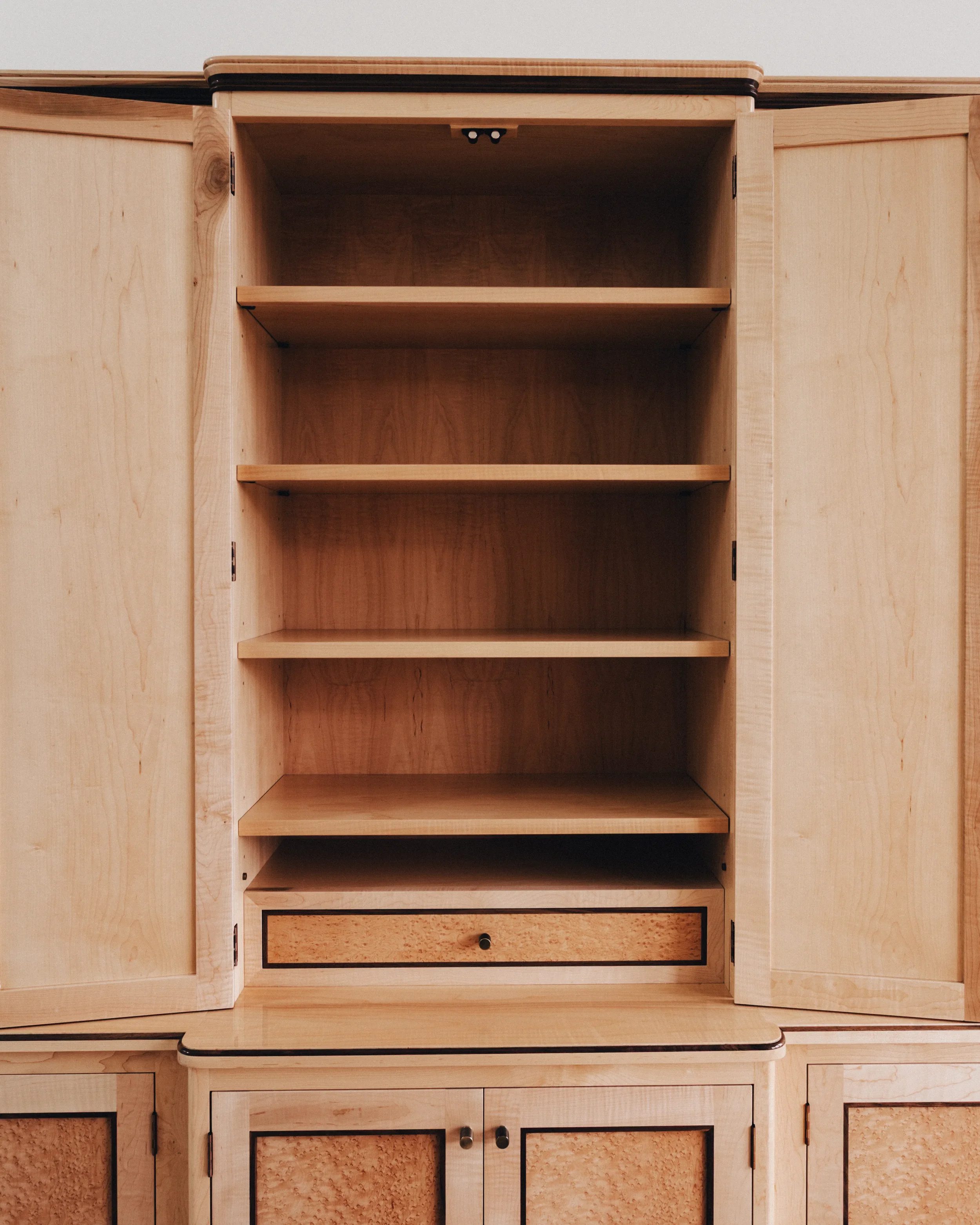A prepared veneer Birdseye Maple and American Black Walnut shelving unit in a high gloss finish with dramatic figuring