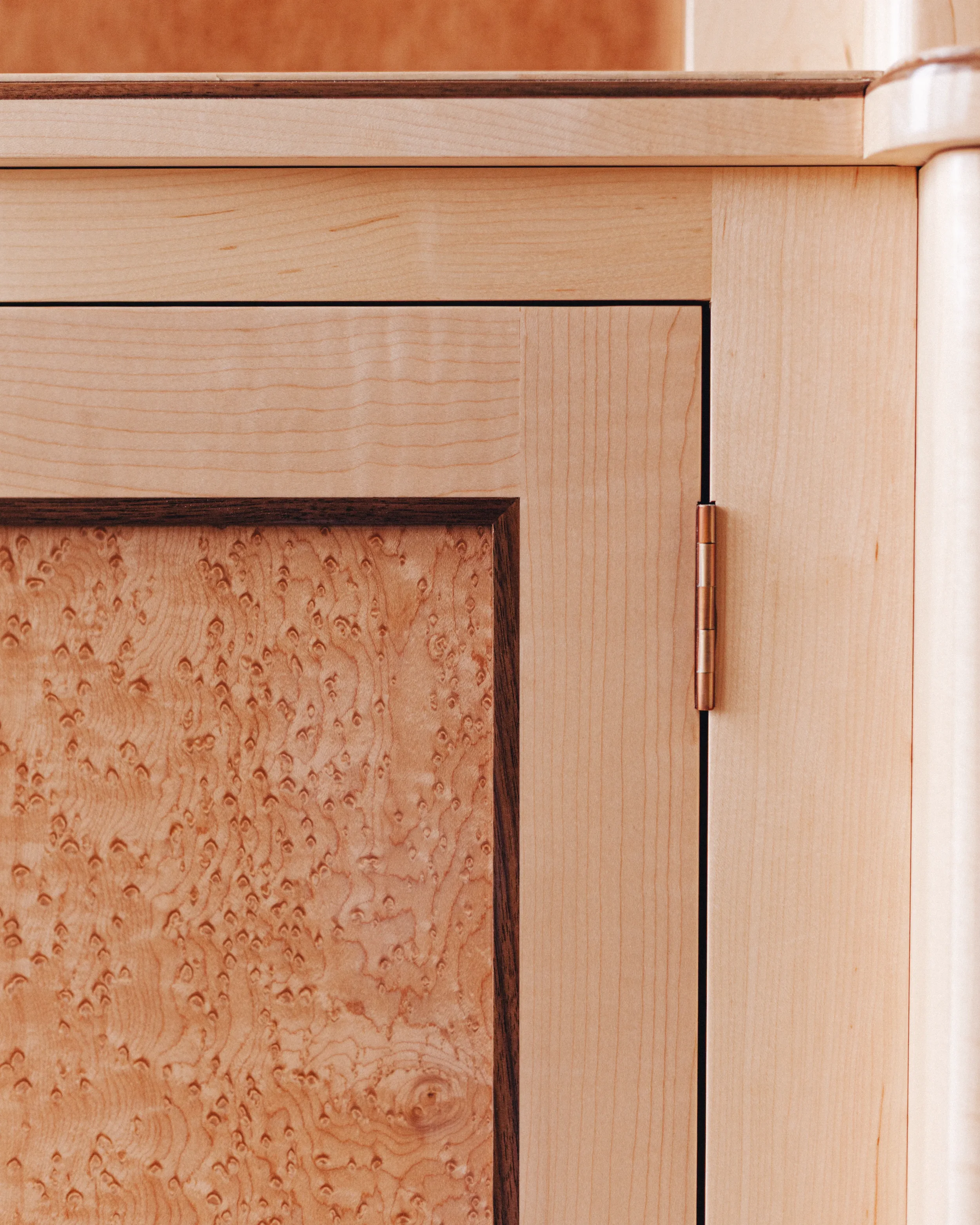 A prepared veneer Birdseye Maple and American Black Walnut shaker doors with contemporary knobs