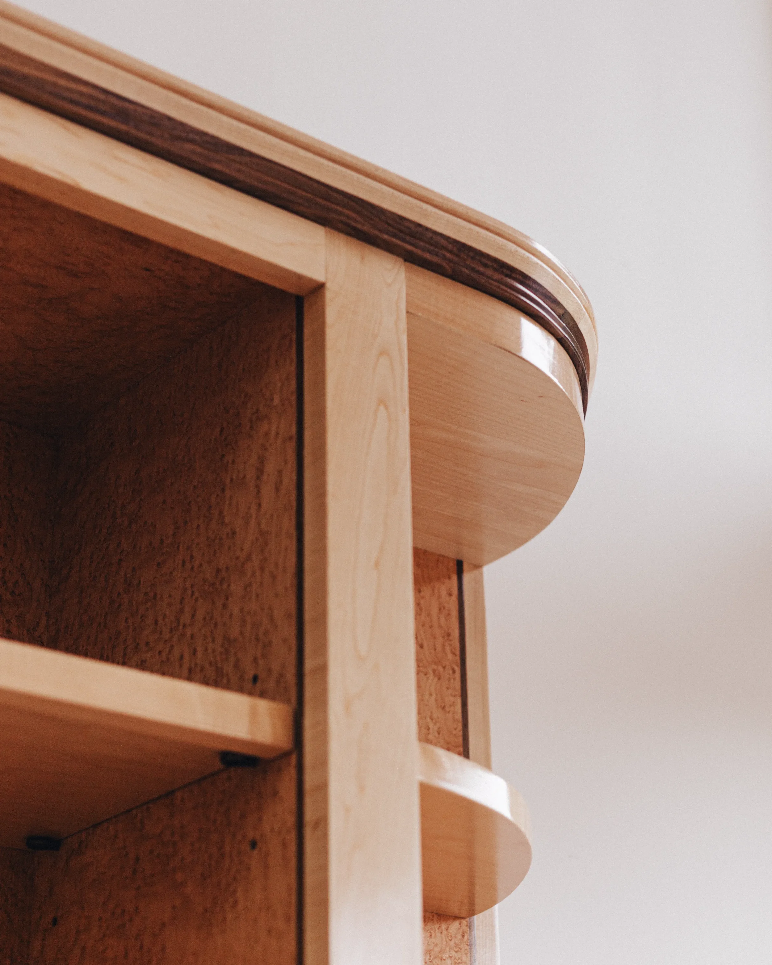 A prepared veneer Birdseye Maple and American Black Walnut shelving unit in a high gloss finish with dramatic figuring and curved shelving