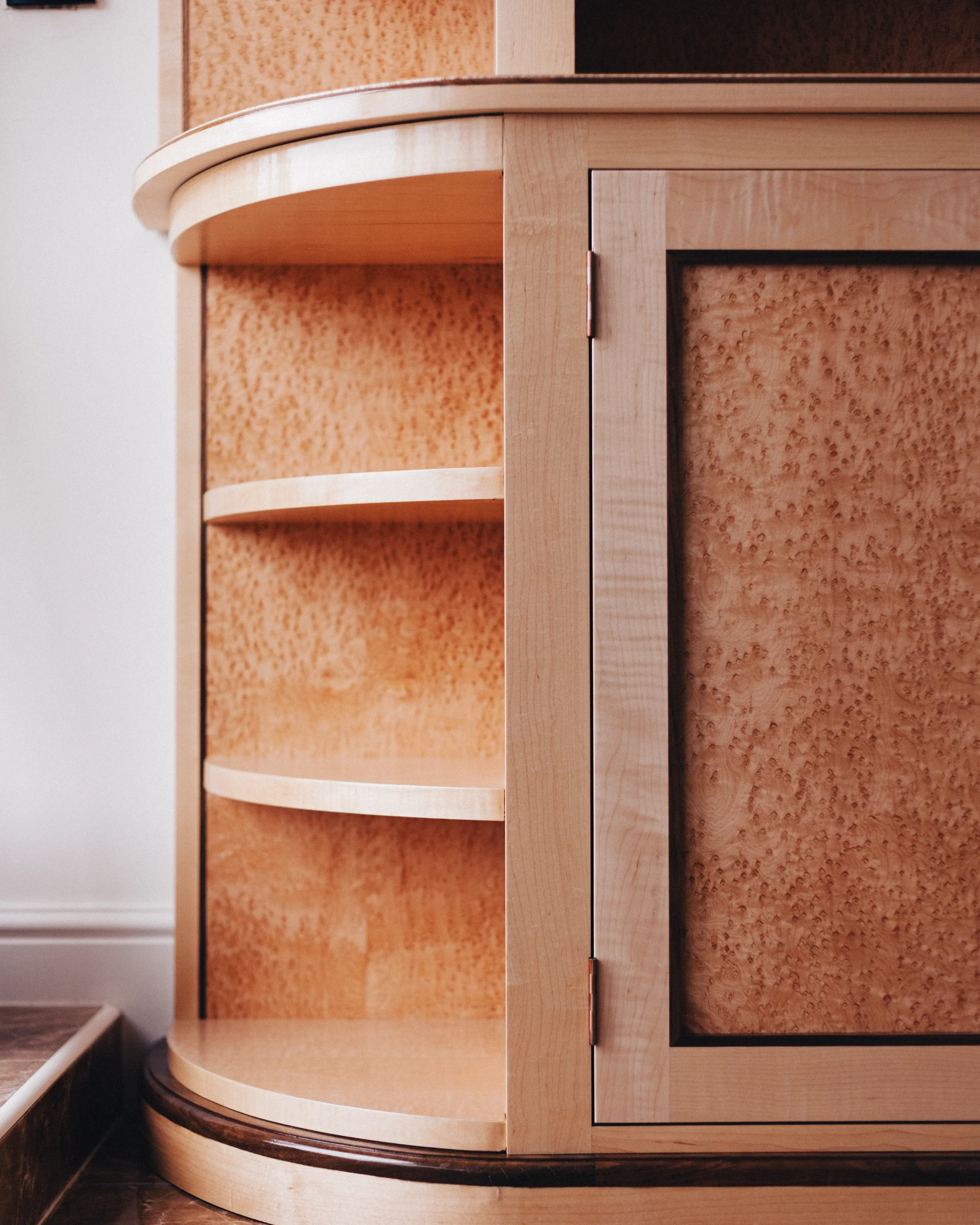 A prepared veneer Birdseye Maple and American Black Walnut shelving unit in a high gloss finish with dramatic figuring and curved shelving