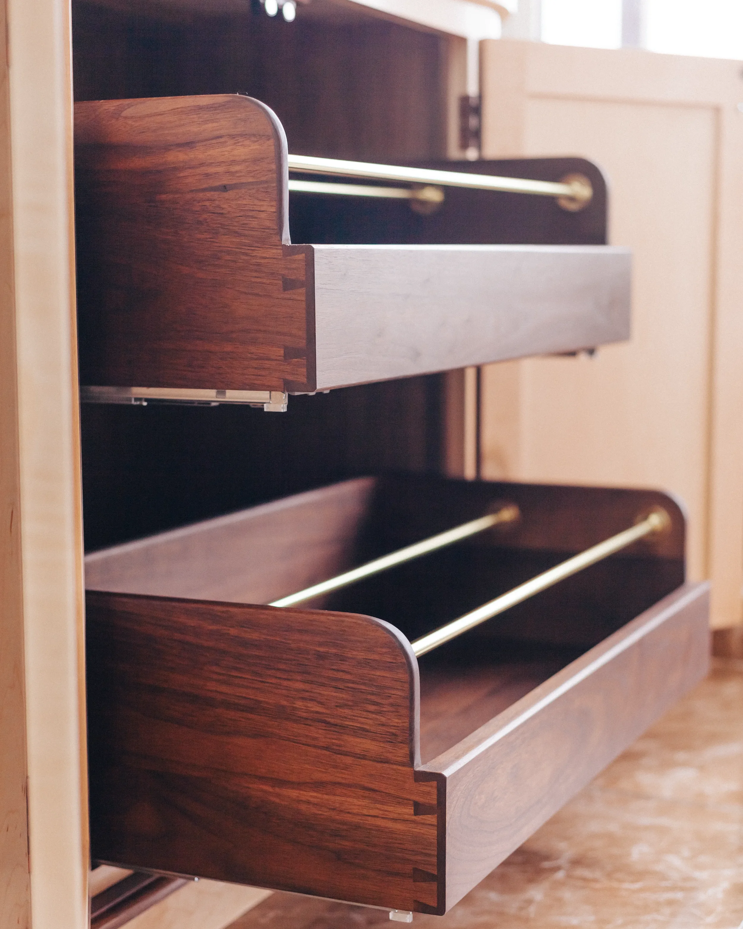 A prepared veneer Birdseye Maple and American Black Walnut shelving unit in a high gloss finish with dramatic figuring and curved shelving featuring solid Walnut shoe storage drawers with brass support rods