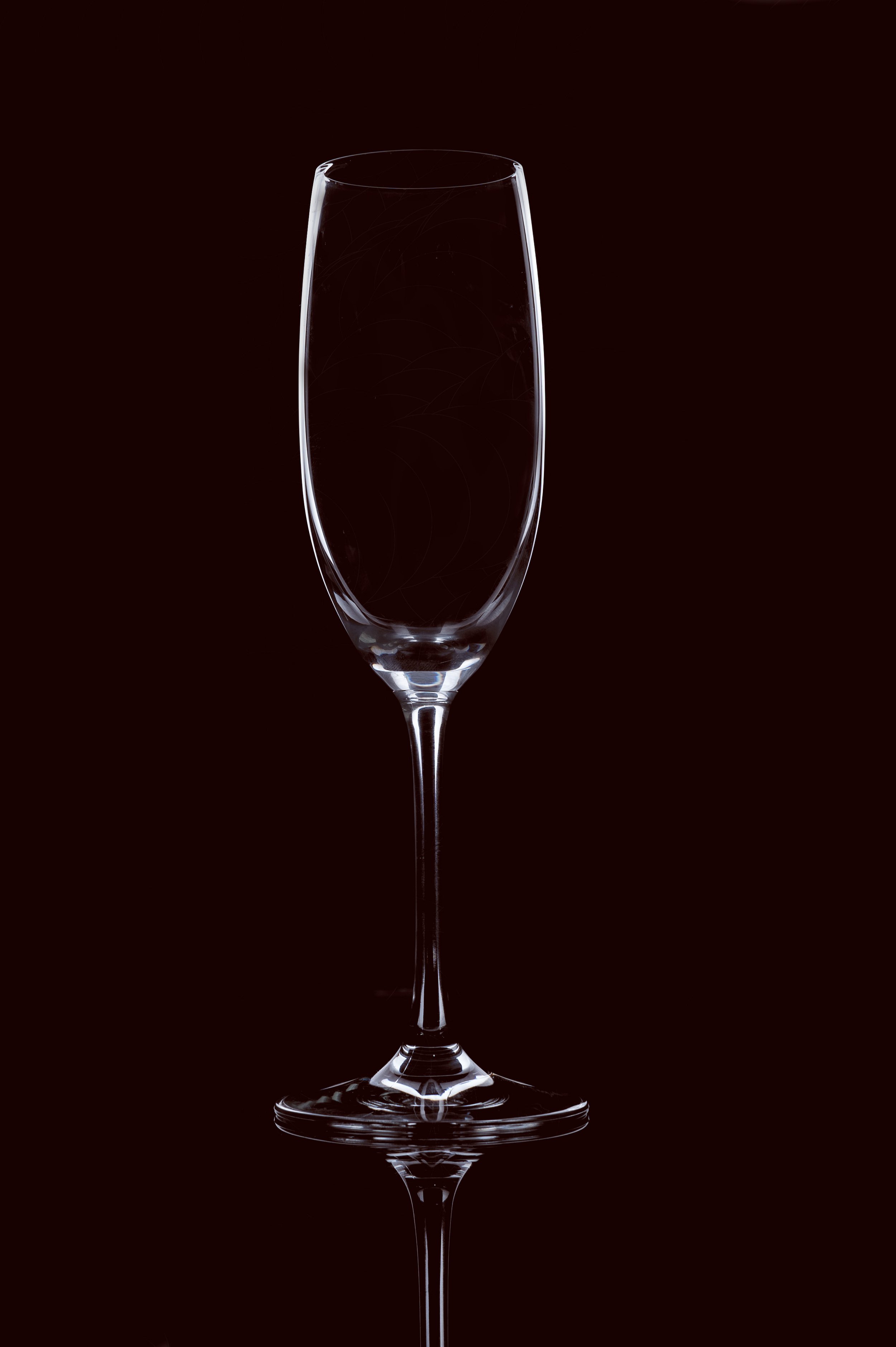 Empty champagne flute glass on a dark background.