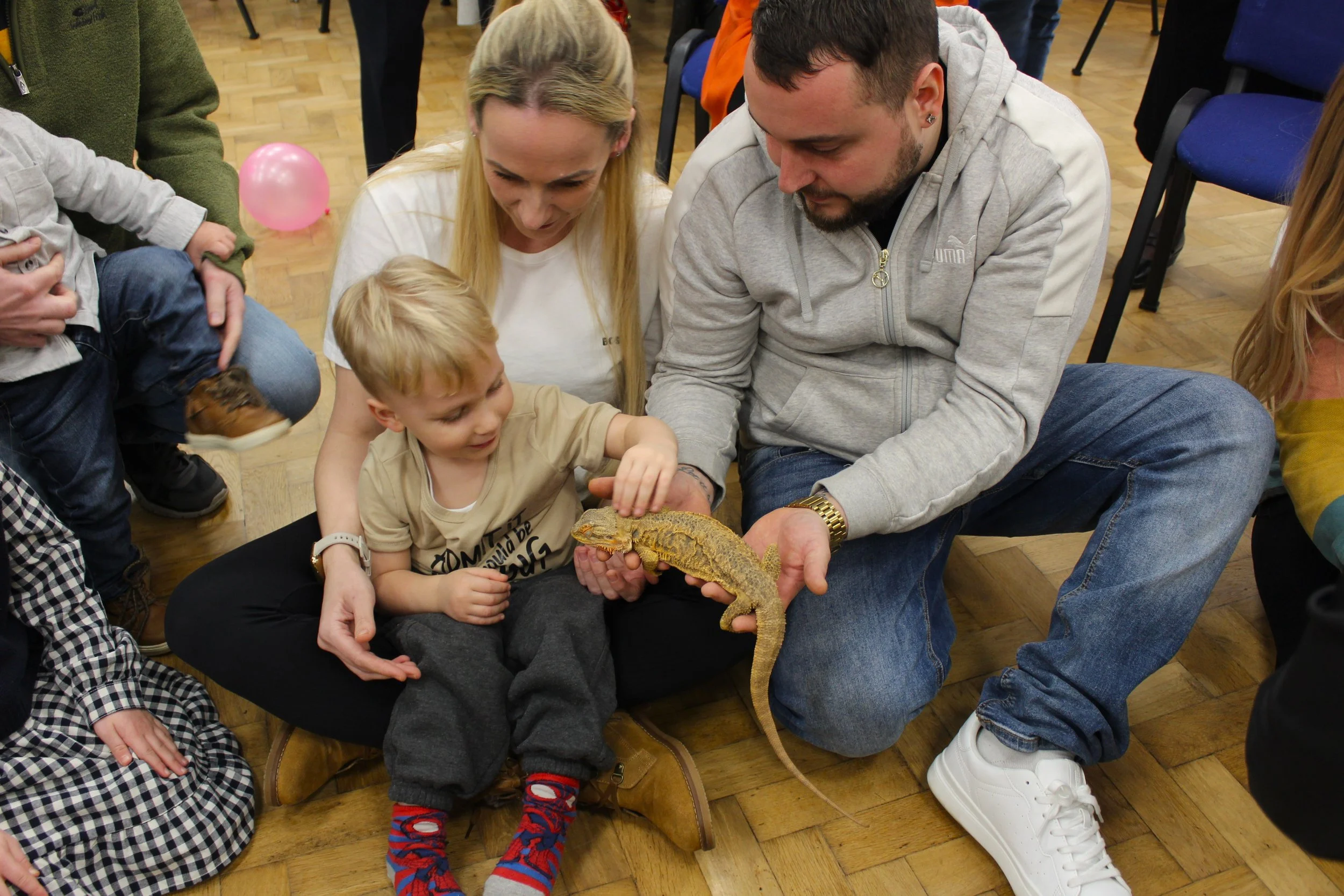 Guests enjoying a hands-on reptile encounter at a community event