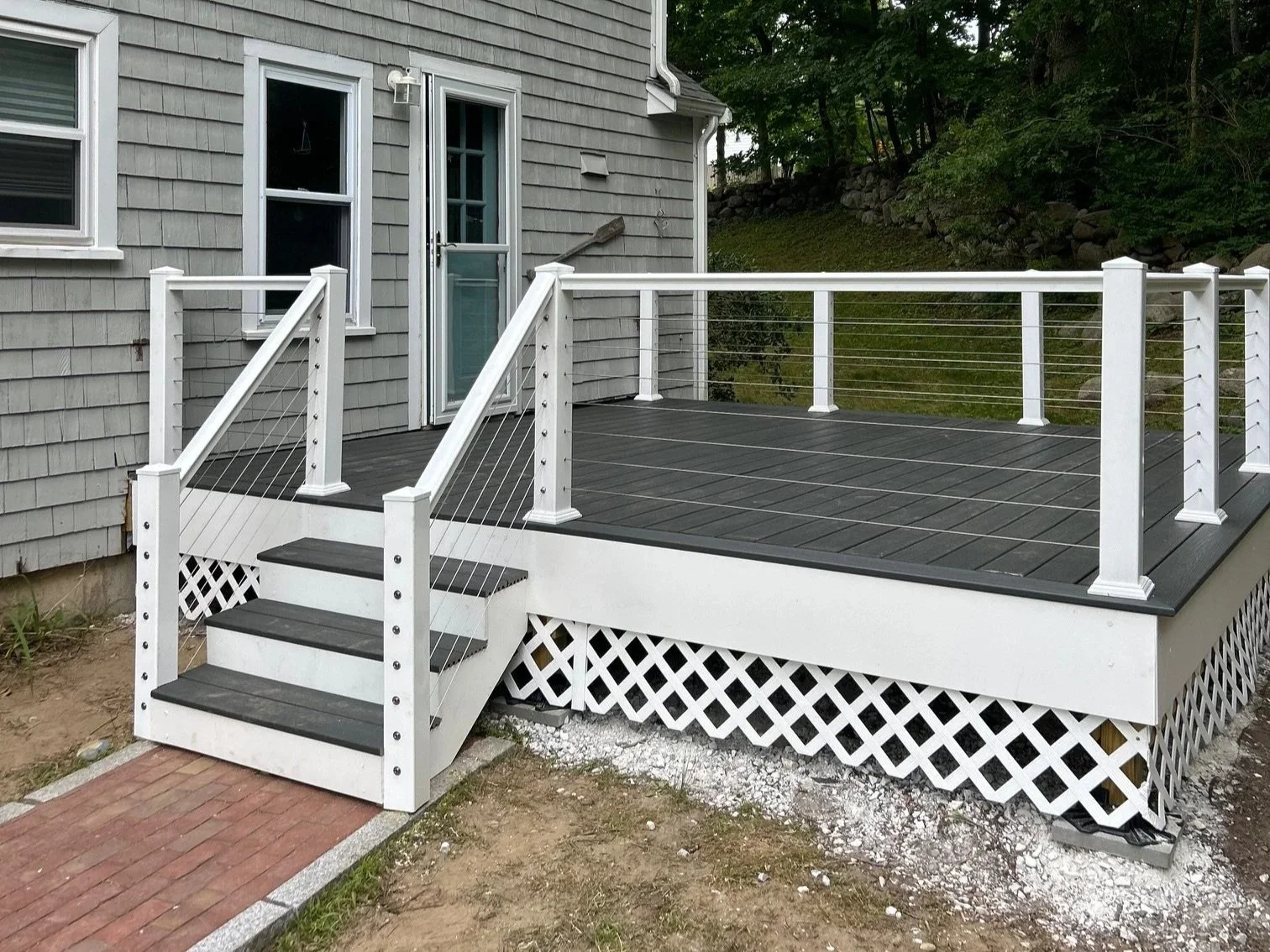 deck that has been rebuilt with trex board, white framing, and invisible cable railing
