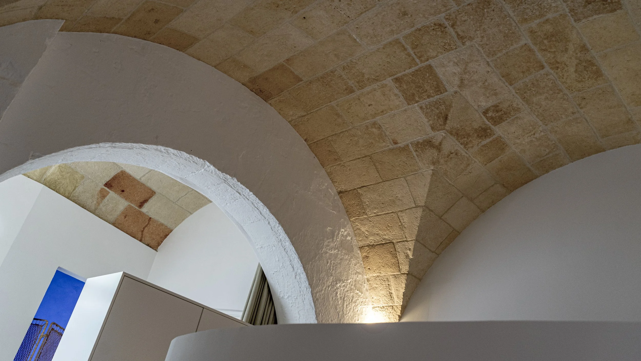 Ceiling with brick arches and white plastered sections, interior view of a historic building or structure.