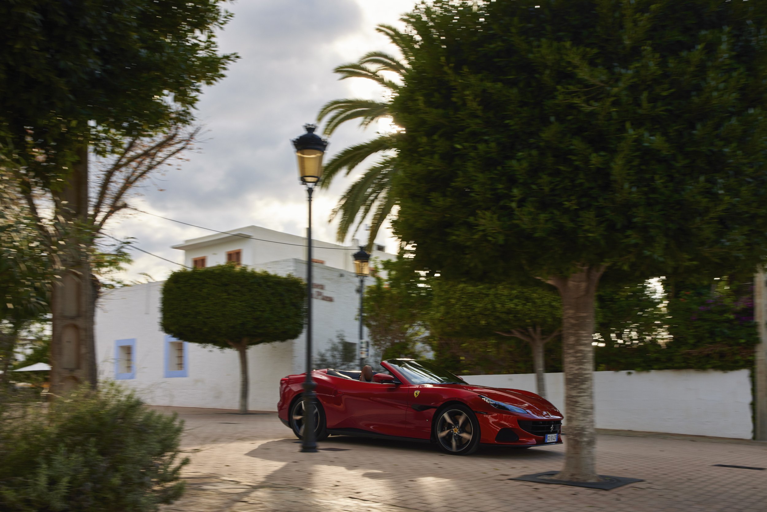 Traversé d'un petit village blanc typique d'Ibiza avec Martin Solveig au volant de la Ferrari Portofino M rouge