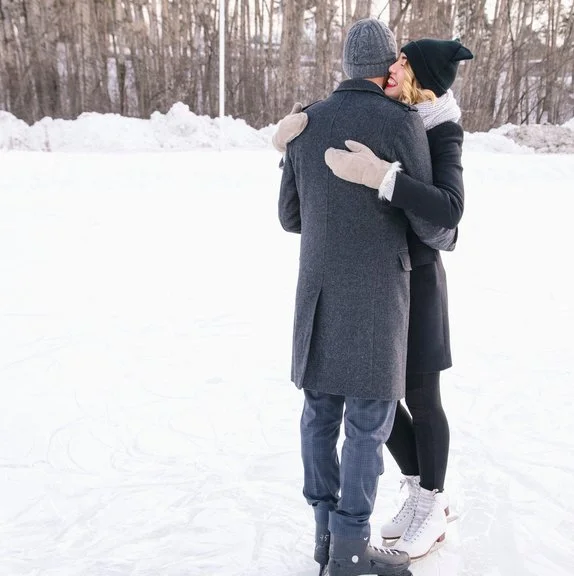 Couple hugging while ice skating in winter