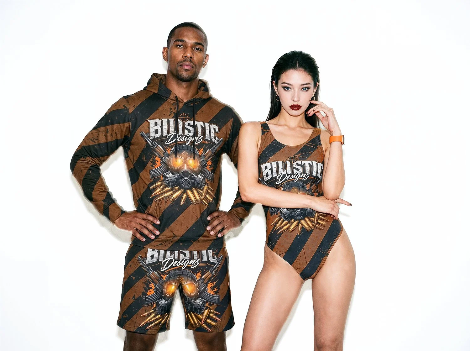 Man and woman posing against a white background, both wearing matching camouflage-style clothing with a gas mask and bullets graphic, and the text 'Biotic Designs' on their outfits.