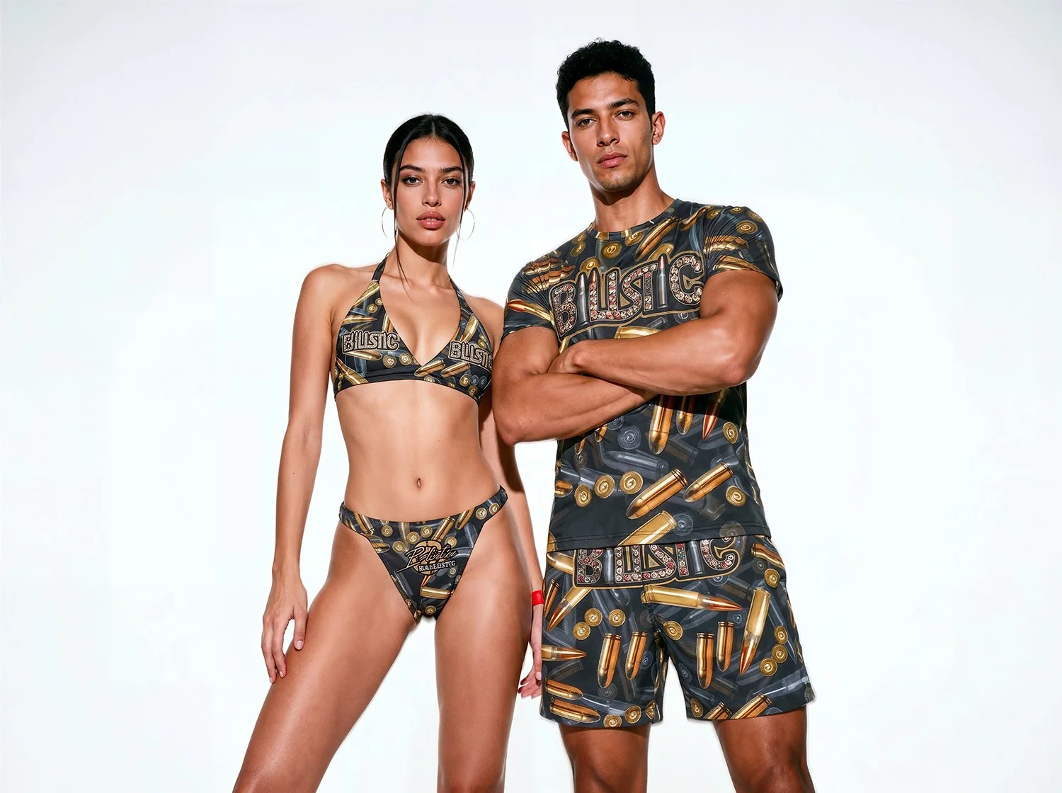 A man and woman standing together wearing matching clothing with bullet patterns and the word 'BULSTIC' printed on both. The woman is wearing a bikini, and the man is wearing a t-shirt and shorts. They are against a plain white background.
