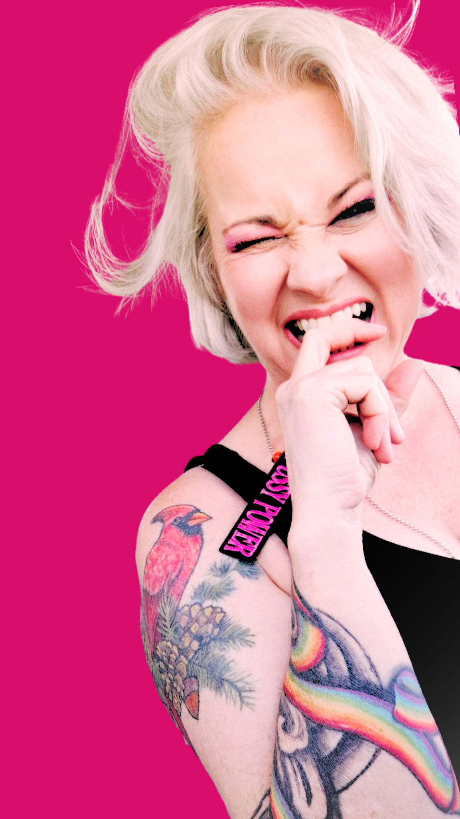 Heidi Oh, Gray hair, tattoos on her arm, winking, with a playful facial expression against a bright pink background.