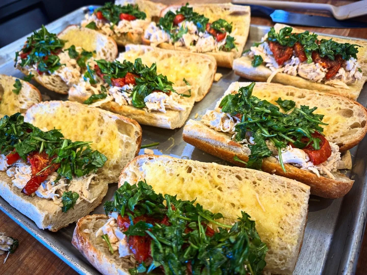 Basil Chicken Chomps are now available! Today we have basil chicken under roasted spiced tomato, balsamic arugula with parsley and oregano, all in a Mazama baguette with melted Filomena and Comte cheeses!