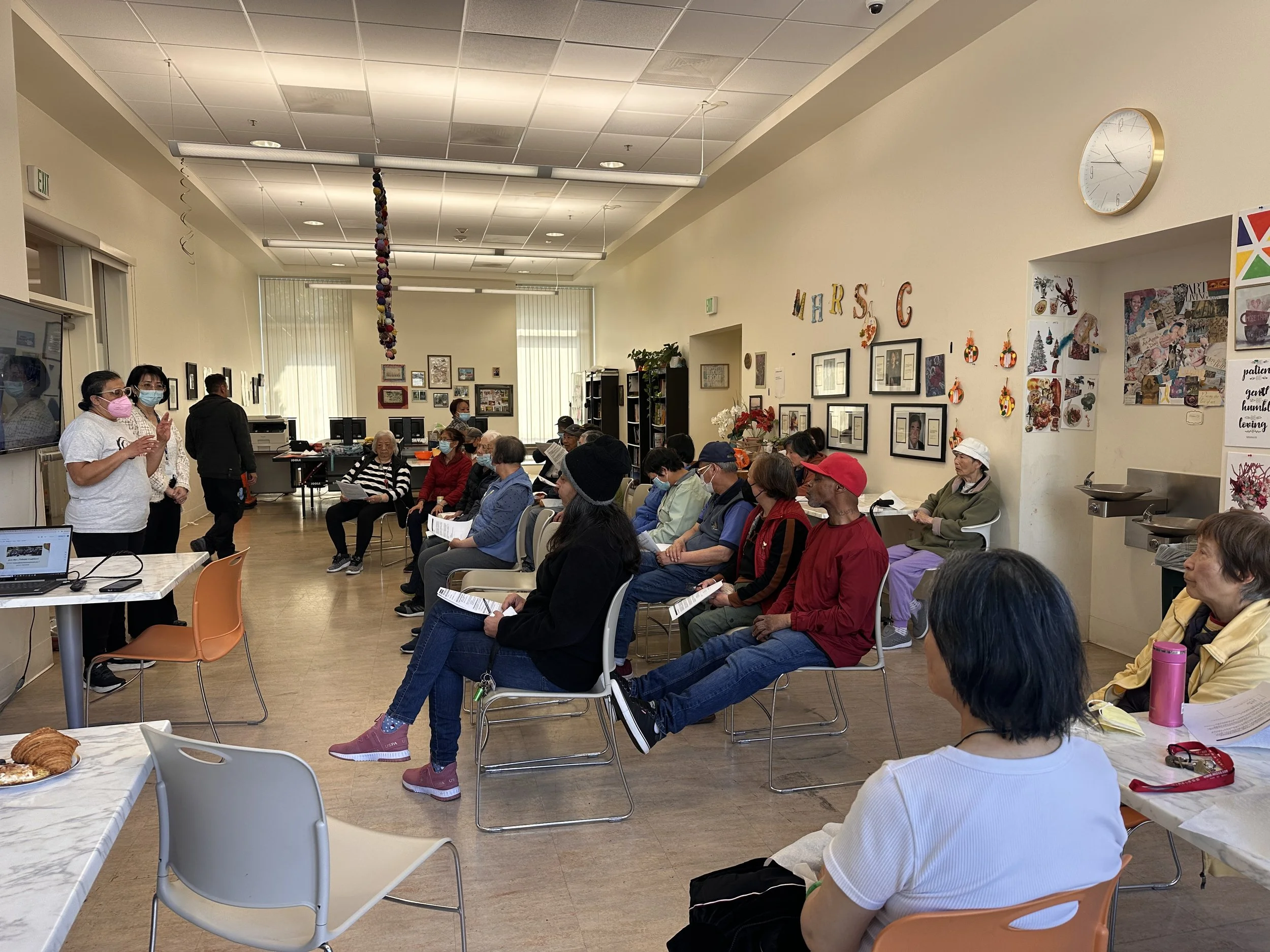 A group of people sitting in chairs watching a presentation