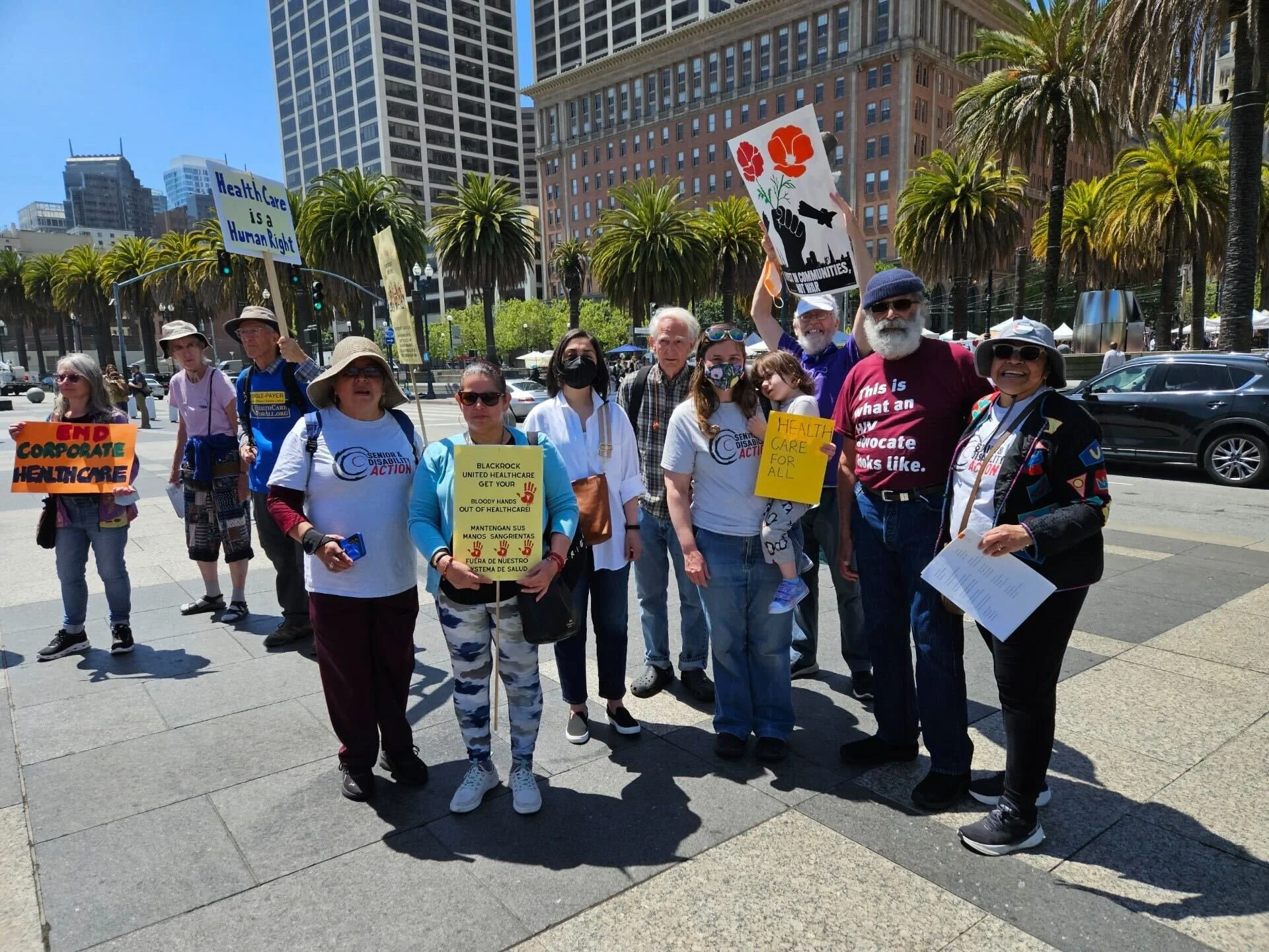 A group of people standing with healthcare related signs in English and Spanish together outside