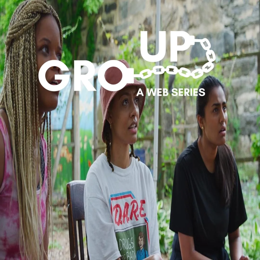 A photo of three girls 2 of them are Black and one of them is South Asian they look shocked. Overlayed are the words Gro Up connected by handcuffs